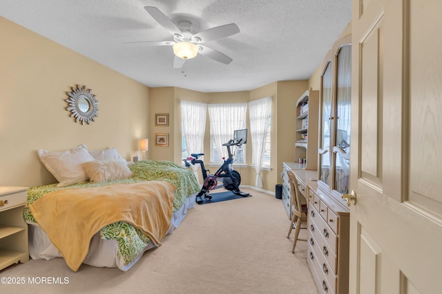 carpeted bedroom featuring ceiling fan and a textured ceiling