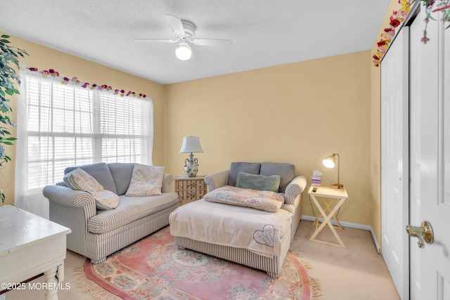 living room featuring a textured ceiling, ceiling fan, and carpet floors