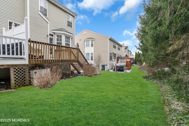 back of property with a yard, a wooden deck, and cooling unit