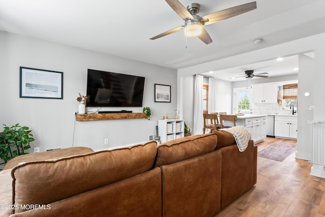 living room featuring light wood-type flooring and ceiling fan