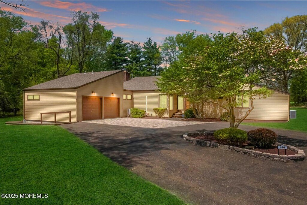 166 Oakland Mills Rd, Manalapan, NJ 07726 - view of front facade featuring asphalt driveway, a front yard, and a garage