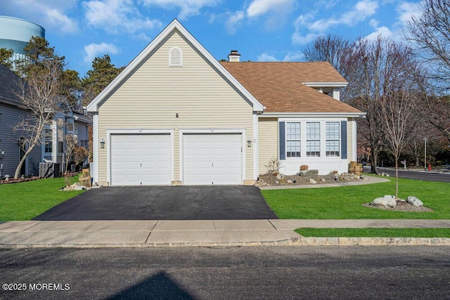 view of front of home with a garage and a front lawn