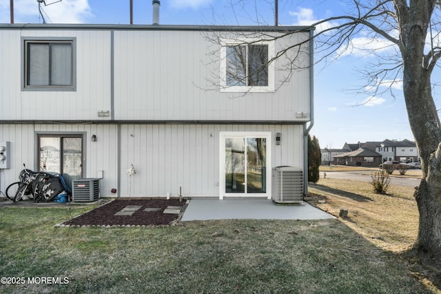 rear view of property with a lawn, central AC, and a patio