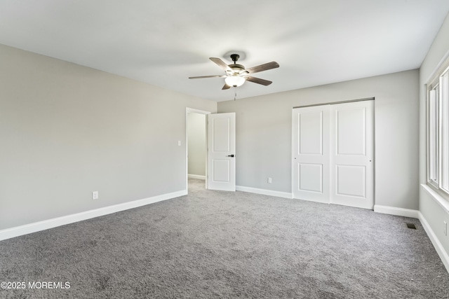 unfurnished bedroom featuring ceiling fan, a closet, and carpet flooring