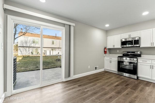 kitchen featuring dark wood-type flooring, white cabinetry, and stainless steel appliances