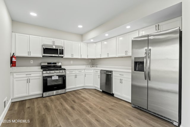 kitchen featuring white cabinets, light wood-type flooring, sink, and stainless steel appliances