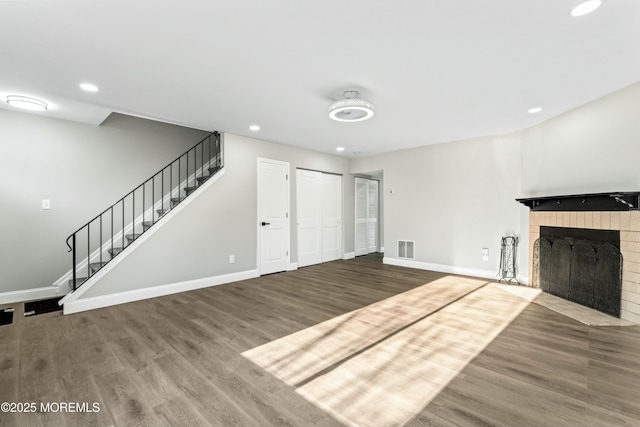 unfurnished living room featuring wood-type flooring and a fireplace