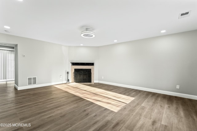 unfurnished living room featuring a fireplace and wood-type flooring