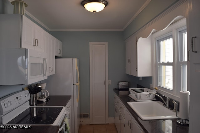 kitchen with white appliances, ornamental molding, white cabinets, light tile patterned flooring, and sink