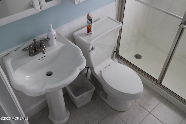 bathroom featuring walk in shower, tile patterned flooring, and toilet