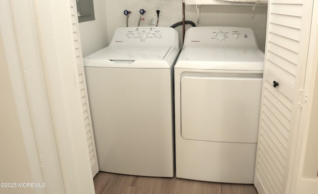 clothes washing area with hardwood / wood-style flooring and washing machine and dryer