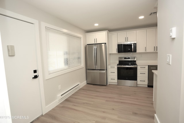 kitchen featuring stainless steel appliances, white cabinets, light wood-type flooring, decorative backsplash, and a baseboard heating unit