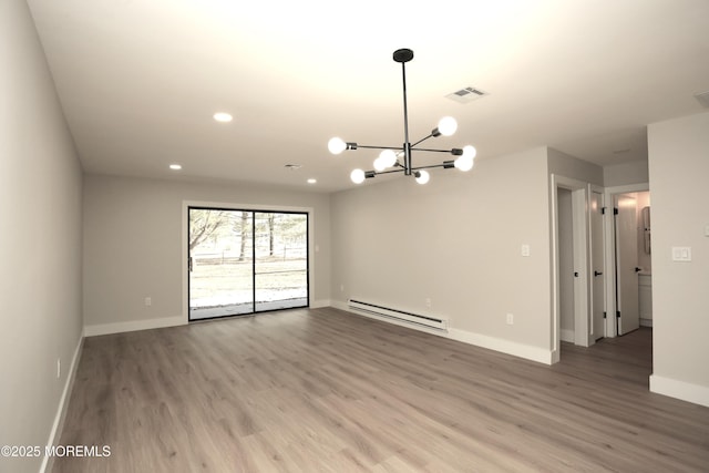 spare room featuring a baseboard radiator, a chandelier, and hardwood / wood-style flooring