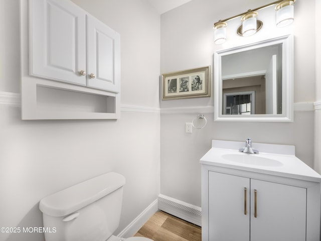 bathroom featuring toilet, wood-type flooring, and vanity