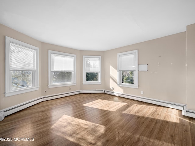 empty room with hardwood / wood-style flooring and plenty of natural light