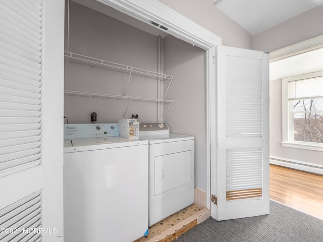 laundry room with carpet floors, independent washer and dryer, and a baseboard heating unit