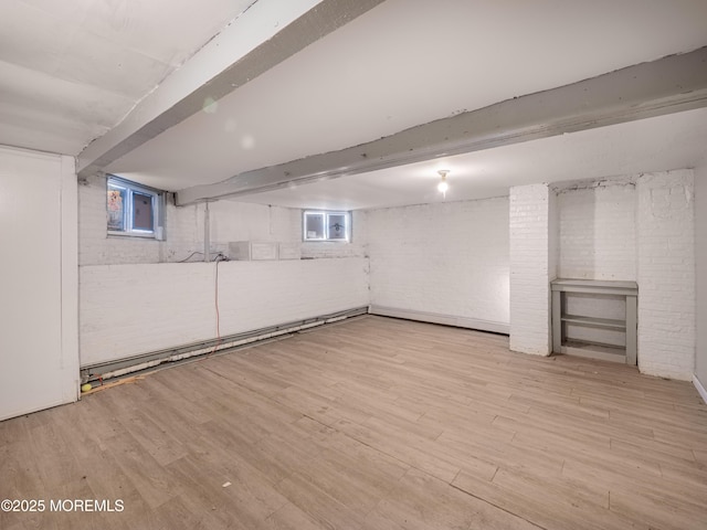 basement with light hardwood / wood-style flooring and a wealth of natural light