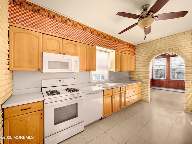 kitchen with brick wall, white appliances, baseboard heating, and light tile patterned floors