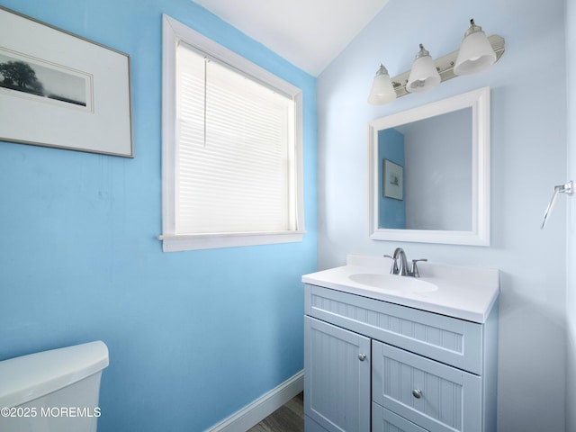 bathroom featuring wood-type flooring, vanity, and toilet