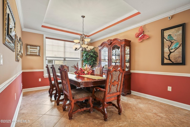 dining area with crown molding, light tile patterned floors, a notable chandelier, and a tray ceiling