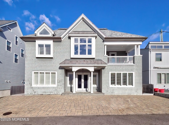 view of front of home with a balcony, french doors, and a patio area