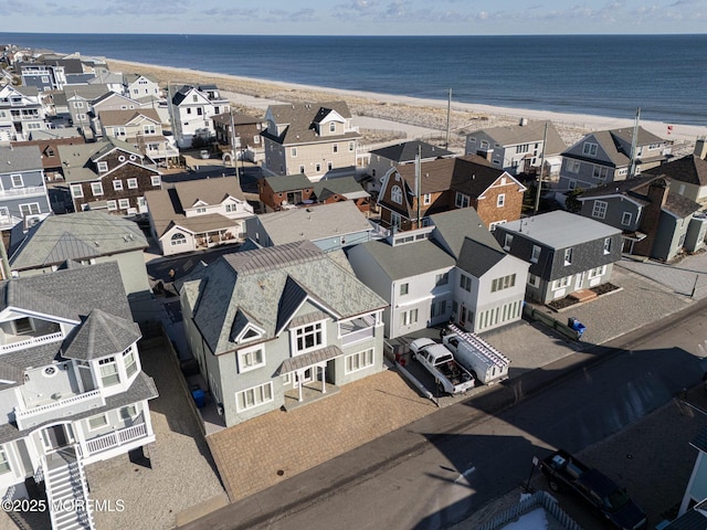 birds eye view of property featuring a beach view and a water view