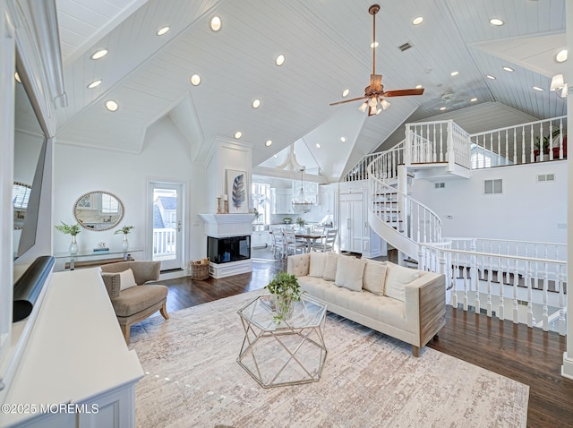 living room featuring hardwood / wood-style floors, wooden ceiling, a multi sided fireplace, ceiling fan, and high vaulted ceiling