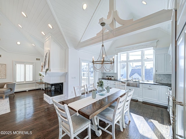 dining room featuring a multi sided fireplace, a healthy amount of sunlight, dark wood-type flooring, high vaulted ceiling, and beam ceiling