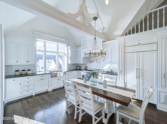 kitchen featuring vaulted ceiling with beams, high quality appliances, pendant lighting, decorative backsplash, and white cabinets