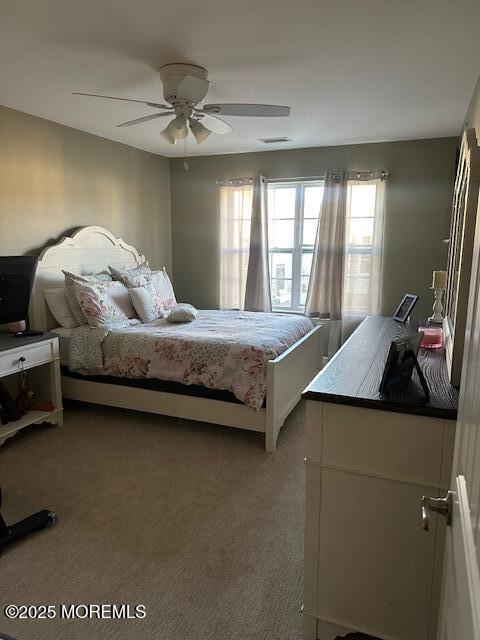 bedroom featuring dark colored carpet and ceiling fan