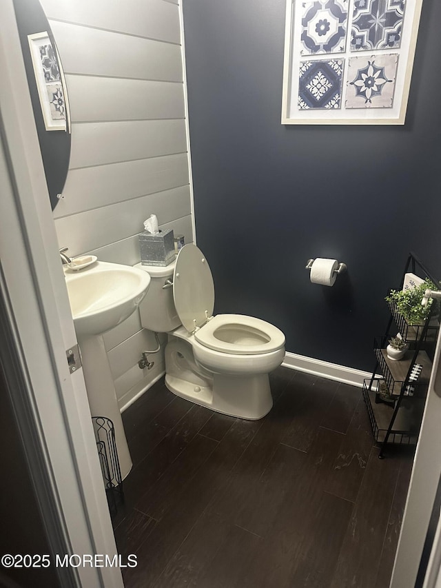 bathroom featuring hardwood / wood-style flooring, toilet, and sink