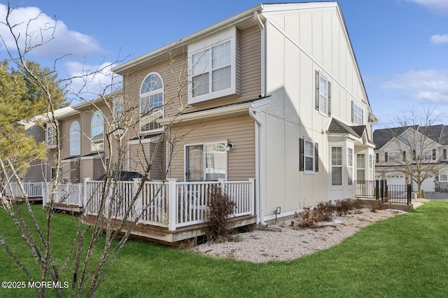 rear view of property with a deck and a lawn