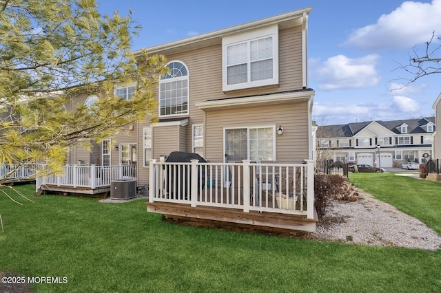 rear view of house with a deck, a lawn, and central AC