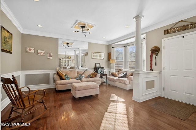 sitting room featuring decorative columns, dark wood-type flooring, and crown molding