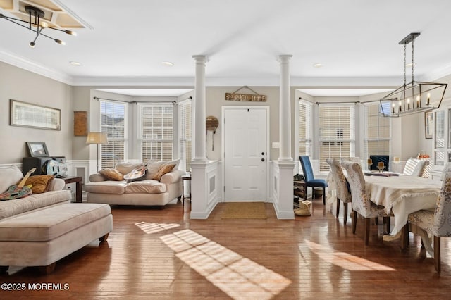 interior space featuring decorative columns, dark wood-type flooring, and an inviting chandelier