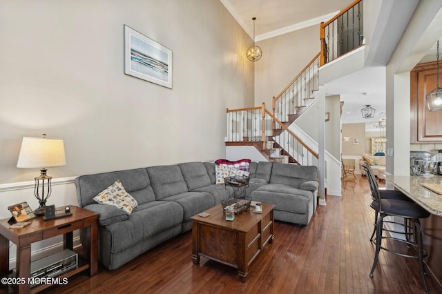 living room with dark wood-type flooring and ornamental molding