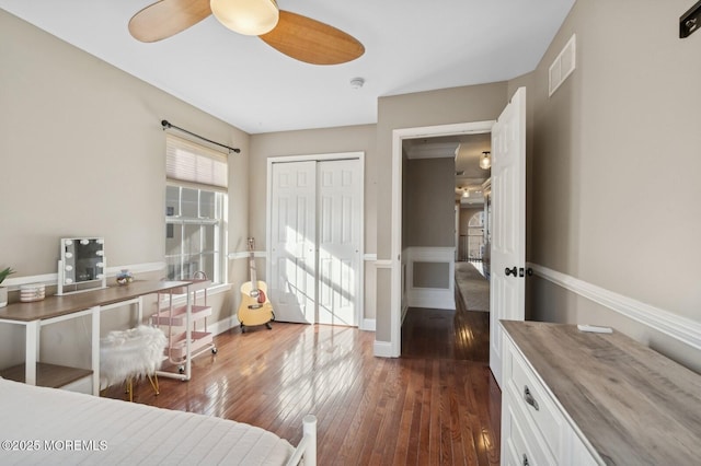 bedroom featuring ceiling fan, a closet, and dark hardwood / wood-style flooring