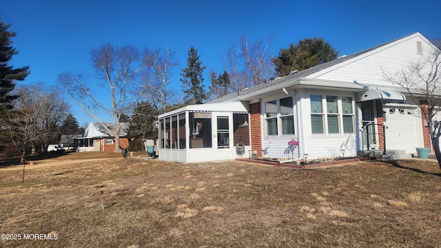 view of front of house featuring a garage, a sunroom, and a front lawn