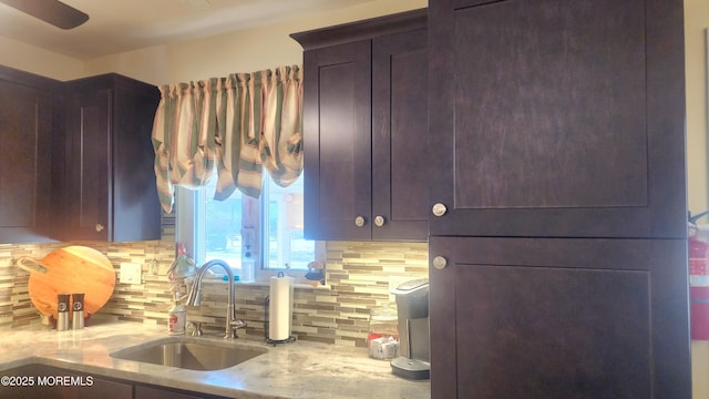 kitchen with sink, light stone counters, and decorative backsplash