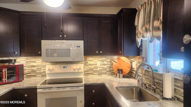 kitchen featuring white appliances, dark brown cabinets, and sink