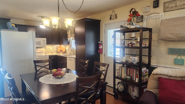 dining space with sink and an inviting chandelier