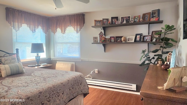 bedroom with a baseboard radiator, ceiling fan, and hardwood / wood-style flooring