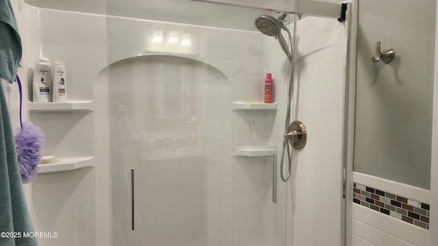 bathroom featuring a shower with shower door