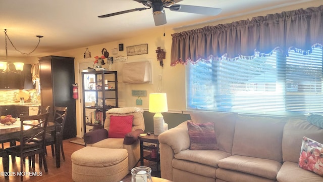 living room featuring sink and ceiling fan with notable chandelier