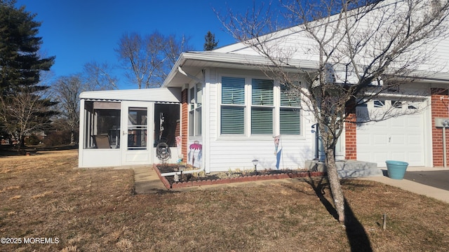 view of front facade with a front lawn, a sunroom, and a garage