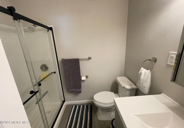 bathroom featuring vanity, toilet, and a shower with shower door