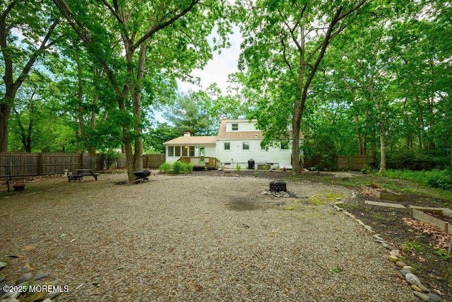 back of property featuring an outdoor fire pit and a wooden deck