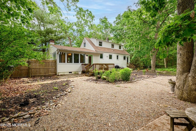 back of house featuring a sunroom and a wooden deck