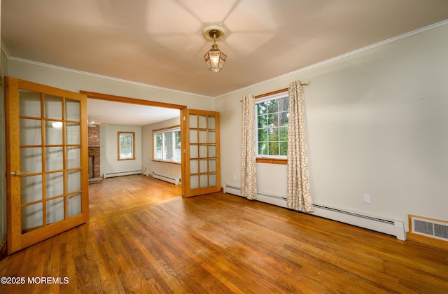 unfurnished room with baseboard heating, crown molding, french doors, and hardwood / wood-style floors