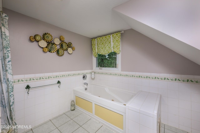 bathroom with tile patterned floors, a tub to relax in, and vaulted ceiling